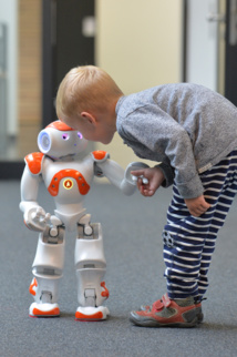 A child with a robot Nao. Source: University of Bielefeld.