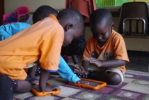 Children from Uganda, with tablets. Source: Curious Learning.